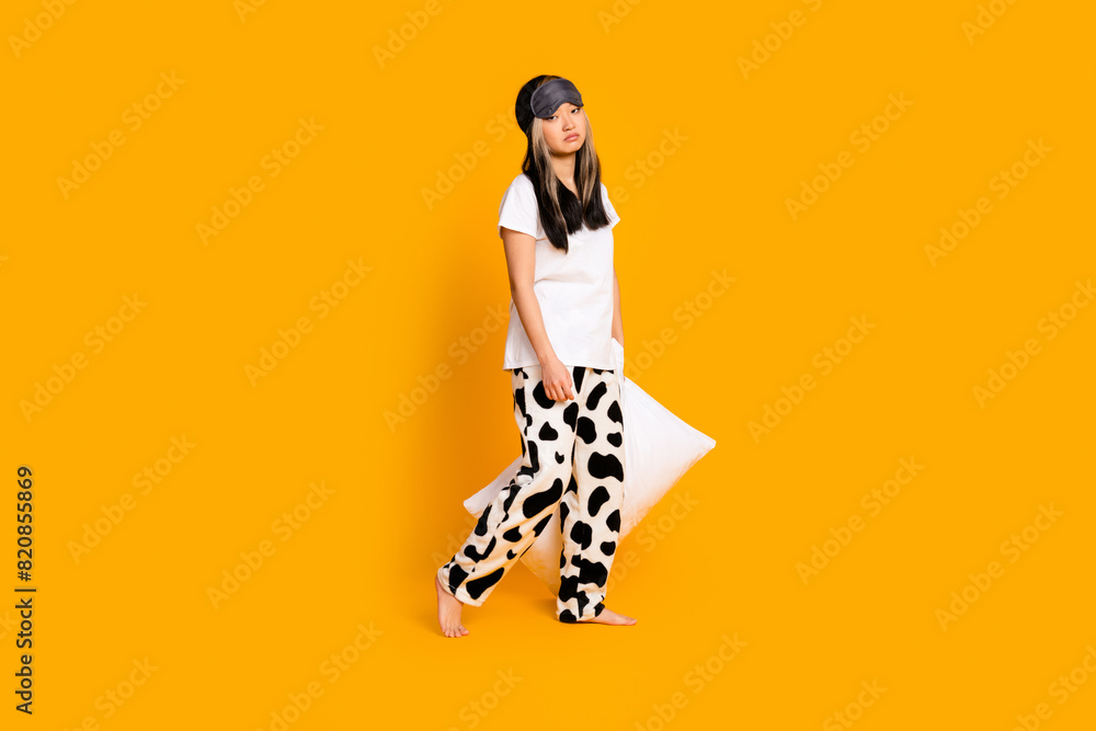 Full length photo of sad adorable nice woman wear white stylish pajama going sleep isolated on yellow color background Full length photo of sad adorable nice woman wear white stylish pajama going sleep isolated on yellow color background