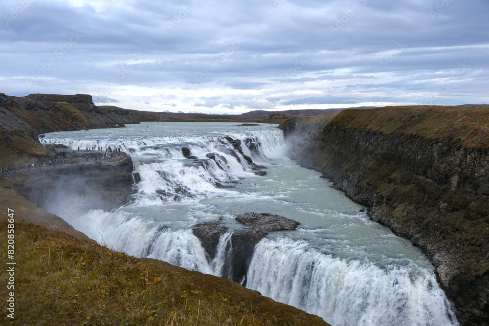 Panoramic view on Gullfoss waterfall on the Hvíta river, a popular tourist attraction and part of the Golden Circle Tourist Route in Southwest Iceland. Golden Waterfall. Panoramic view on Gullfoss waterfall on the Hvíta river, a popular tourist attraction and part of the Golden Circle Tourist Route in Southwest Iceland. Golden Waterfall.