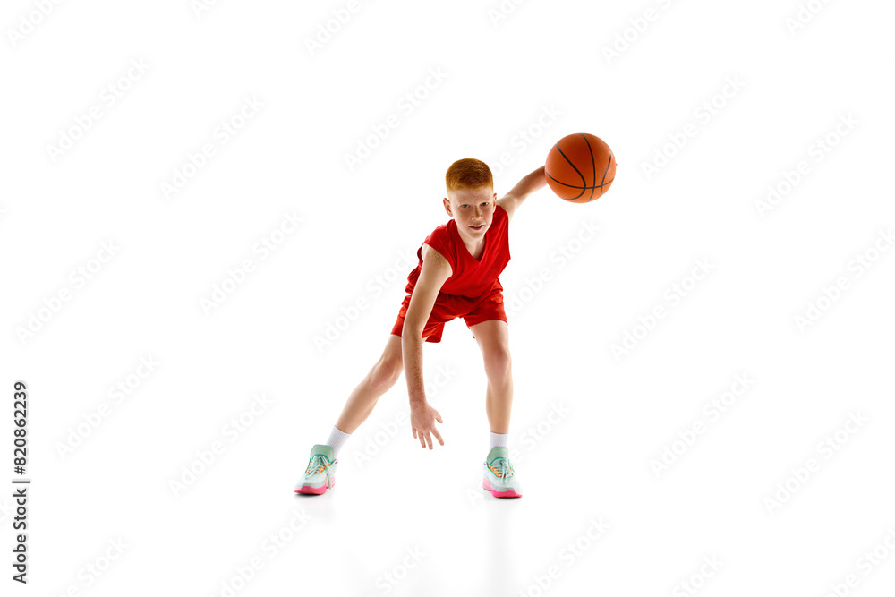 Motivated teen boy, basketball player in dynamic pose with ball, practicing, playing isolated on white studio background. Concept of sport, childhood, sport school, active lifestyle Motivated teen boy, basketball player in dynamic pose with ball, practicing, playing isolated on white studio background. Concept of sport, childhood, sport school, active lifestyle