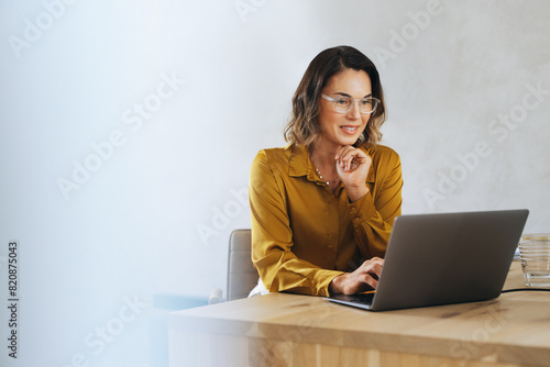 Business woman using a laptop for an online meeting in her office