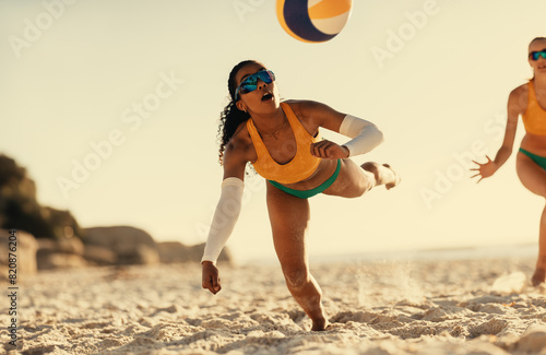 Beach volleyball: Black woman soars in air to reach ball photo