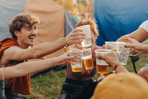 Friends raise their beers in a celebratory toast, capturing a moment of festival fun photo