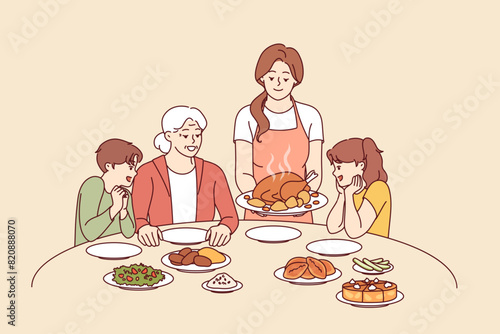 Family celebration of thanksgiving with joint dinner and delicious turkey cooked according to catholic traditions. Caring mother serves poultry meat baked in oven during thanksgiving dinner