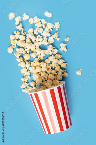 Popcorn bucket, classic crunchy snack, theater movie striped box,blue background