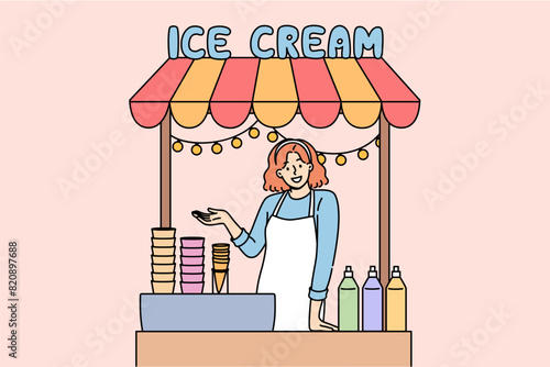 Woman sells ice cream in street stall and makes gesture inviting you to try cold dessert. Girl selling ice cream in waffle cones with addition of sweet syrups to quench summer thirst