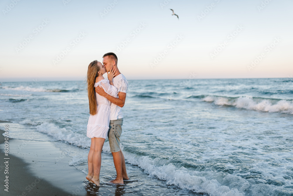Man embraces woman walk on sand sea. Female kiss and hugs male stand ...