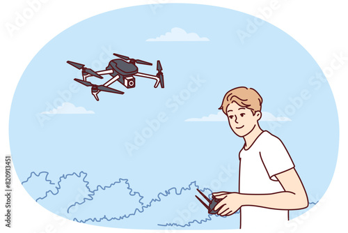 Teenage boy launches quadcopter using remote control and makes aerial photography from drone. Guy has hobby launching miniature aircraft or quadcopter with remote operation wanting to become operator