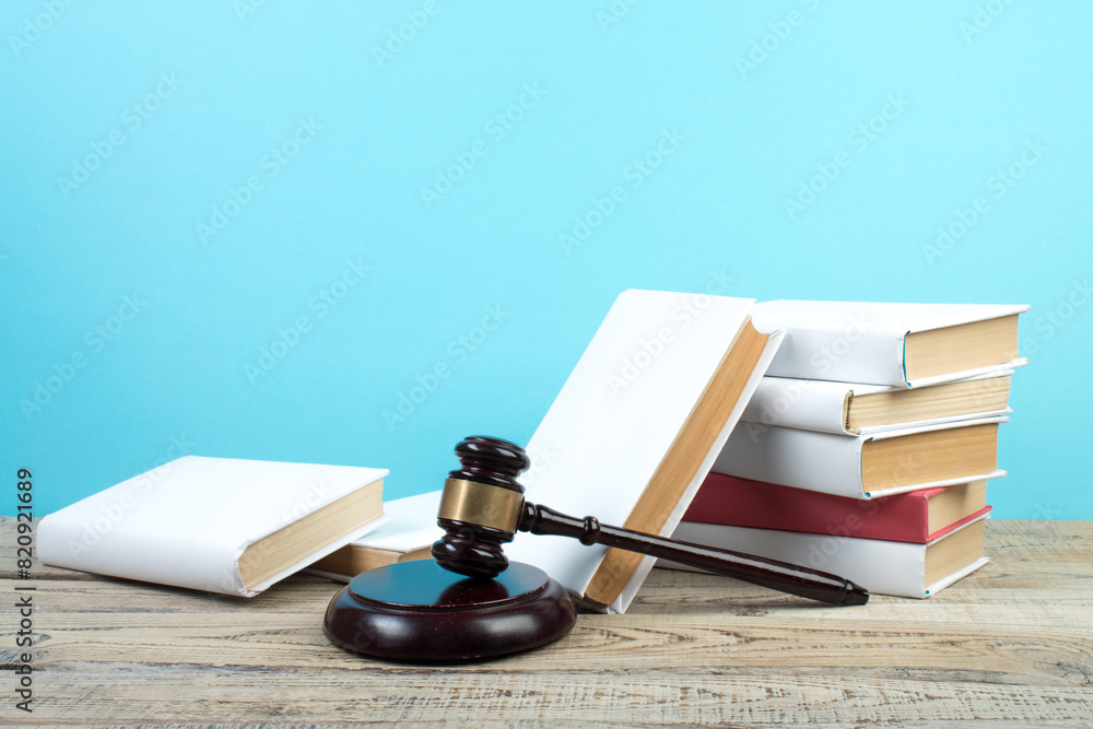 Law concept - Open law book with a wooden judges gavel on table in a courtroom or law enforcement office isolated on white background. Copy space for text. Law concept - Open law book with a wooden judges gavel on table in a courtroom or law enforcement office isolated on white background. Copy space for text.