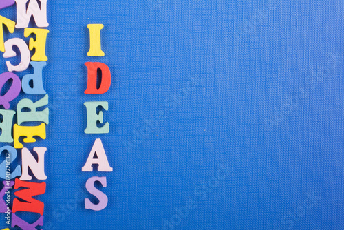 IDEAS word on blue background composed from colorful abc alphabet block wooden letters, copy space for ad text. Learning english concept. photo