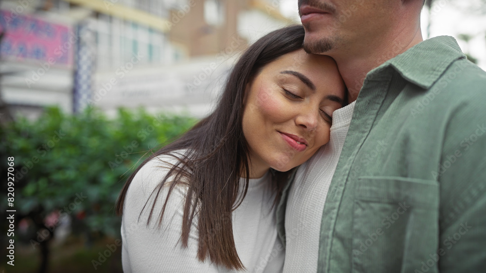 Fototapeta premium A loving couple embraces on a city street, exuding affection with a serene urban backdrop.
