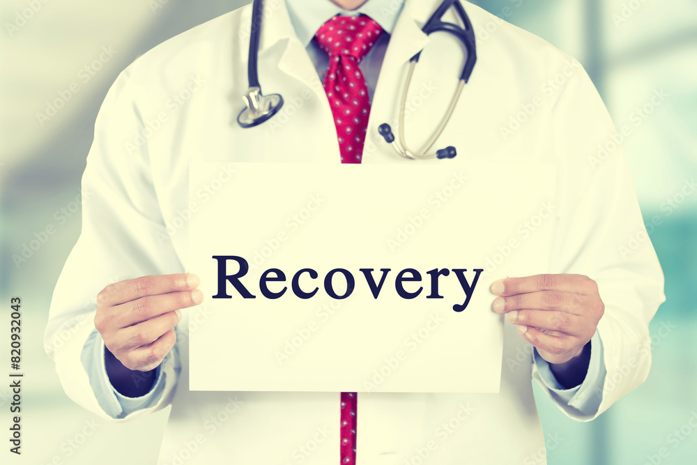 Closeup of doctor hands holding white card with recovery text message isolated on hospital clinic office background. Closeup of doctor hands holding white card with recovery text message isolated on hospital clinic office background.