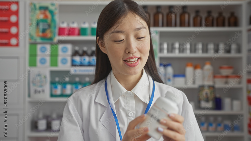 Chinese pharmacist woman examining medication in a modern drugstore Chinese pharmacist woman examining medication in a modern drugstore