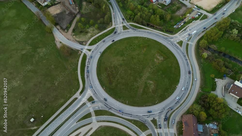 Aerial view of a roundabout in countryside with smooth traffic flow, roads, vehicles passing through green fields Aerial view of a roundabout in countryside with smooth traffic flow, roads, vehicles passing through green fields