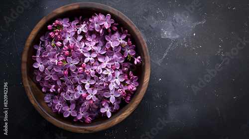 Wooden bowl of beautiful fragrant lilac flowers 