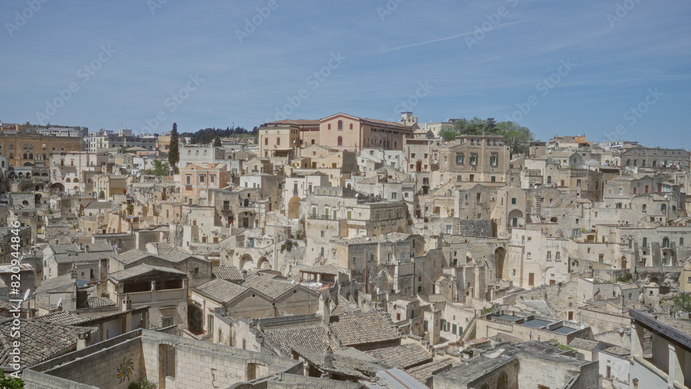 A panoramic view of the ancient stone townscape in matera, basilicata, italy, showcasing its historic architecture under a clear blue sky.