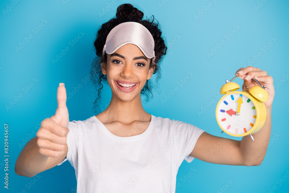 Portrait of pretty young woman thumb up alarm wear pajama isolated on blue color background Portrait of pretty young woman thumb up alarm wear pajama isolated on blue color background