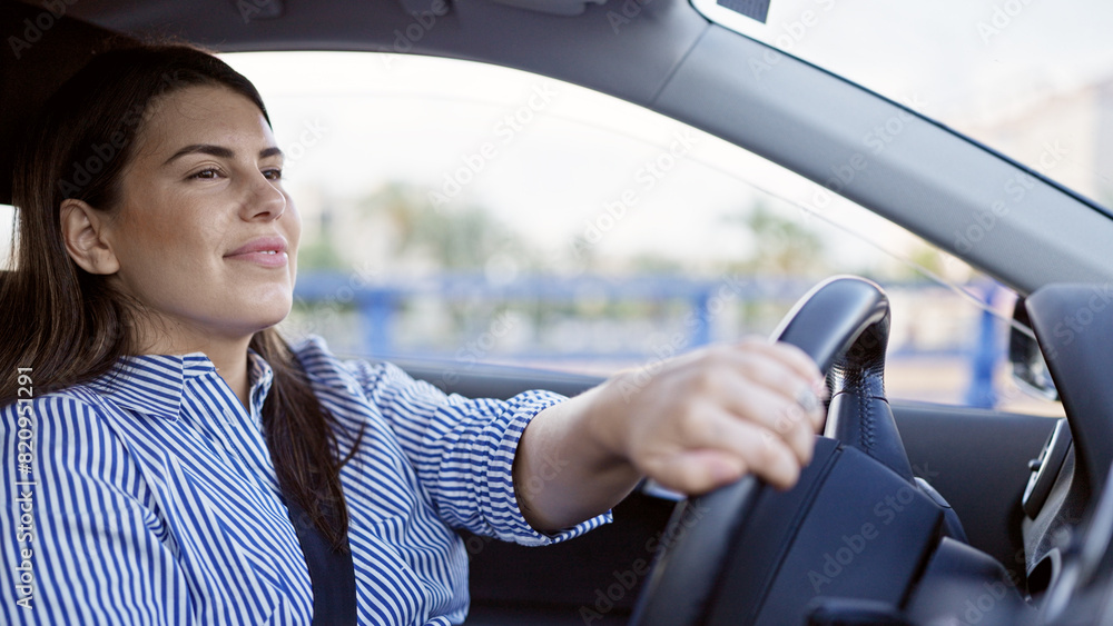 Young beautiful hispanic woman driving a car smiling on the road Young beautiful hispanic woman driving a car smiling on the road