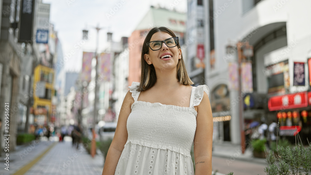 Globe-trotting beauty, stunning adult hispanic woman with glasses, looking around the vibrant tokyo cityscape. this brunette tourist is mesmerized by japan's urban architecture. Globe-trotting beauty, stunning adult hispanic woman with glasses, looking around the vibrant tokyo cityscape. this brunette tourist is mesmerized by japan's urban architecture.