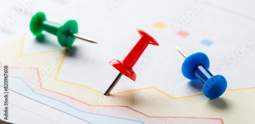 Marking financial chart by pins.Share listing and checking financial chart. Concept of banking, financial report and financial audit.