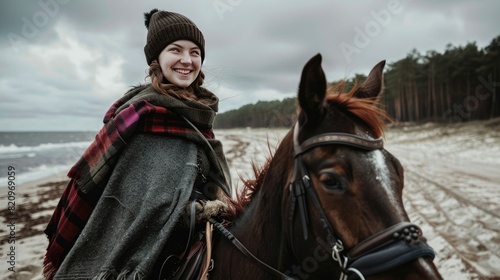 woman riding a horse along a stunning beach, her eyes gleaming with joy as she smiles. © lililia