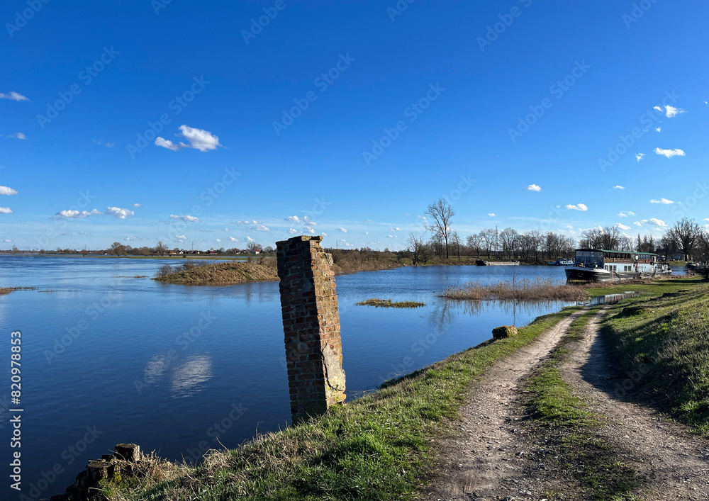 Beautiful spring landscape.
River flood. Blue sky. Reflections in the water.