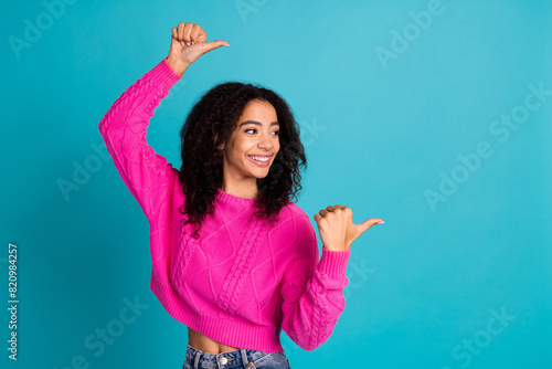 Portrait of nice young girl look point fingers empty space wear pink pullover isolated on turquoise color background photo