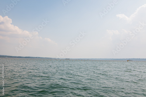 Seascape with floating buoys and rope separation area on the beach. A safety zone towing buoy floats above the sea.