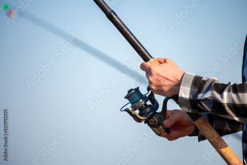Close-up of fishing rod reels. Fishing on the shore of the lake. Spinning rods for sport fishing.