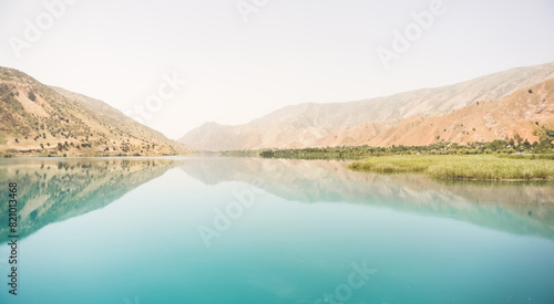 Panorama in nature, the Vakhsh river in Tajikistan, landscape on a hot summer sunny day in Asia, reflection in the blue mirror water of the river photo