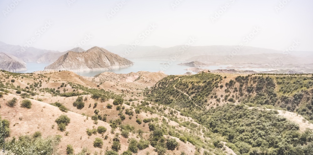 Panoramic view of the Nurek reservoir in the mountains of Tajikistan, landscape of a blue lake in the hot mountains