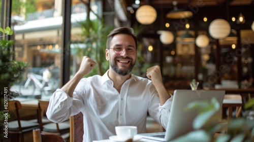 Successful Young Man Celebrating Achievement at Cafe