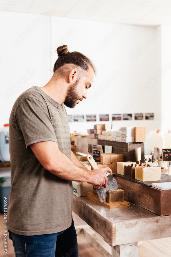 Attendant Slicing Artisan Soap at an Eco-Friendly Bulk Grocery Store Attendant Slicing Artisan Soap at an Eco-Friendly Bulk Grocery Store