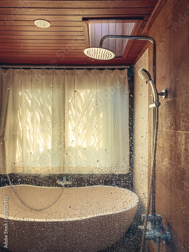 Shower and stone bathtub in bathroom with window