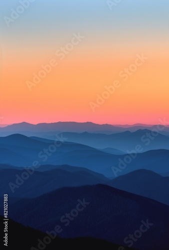 A beautiful sunrise over the mountains, with a clear blue sky and some silhouettes of hills in the background.