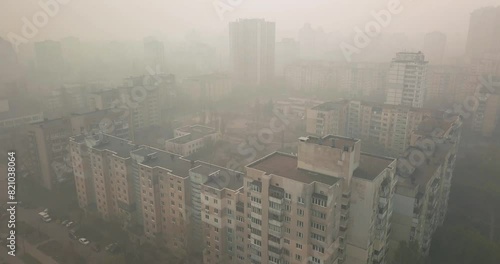 View from a drone during the day of a city shrouded in smoke from summer forest fires
