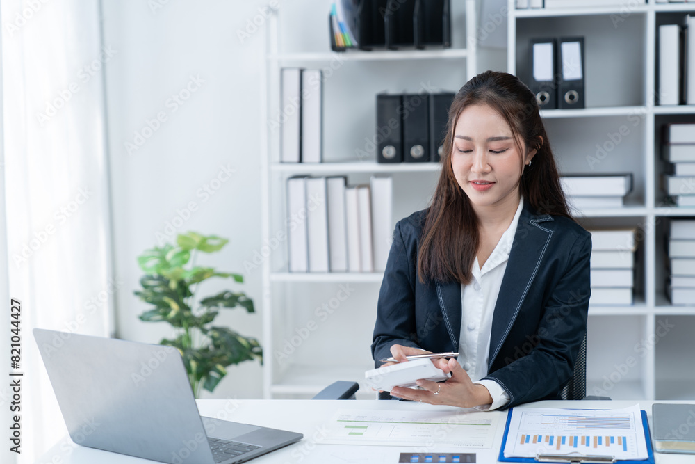 happy young businesswoman Asian siting on the chiar cheerful demeanor raise holding coffee cup smiling looking laptop screen.Making opportunities female working successful in the office. happy young businesswoman Asian siting on the chiar cheerful demeanor raise holding coffee cup smiling looking laptop screen.Making opportunities female working successful in the office.