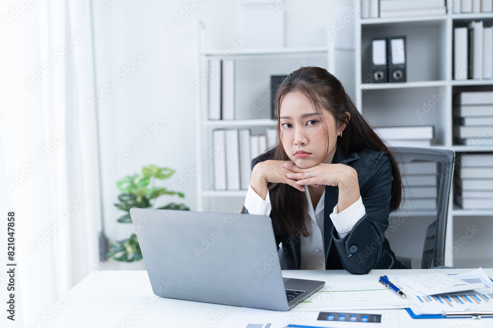 Sharing good business news. Attractive young businesswoman talking on the mobile phone and smiling while sitting at her working place in office and looking at laptop PC. Sharing good business news. Attractive young businesswoman talking on the mobile phone and smiling while sitting at her working place in office and looking at laptop PC.