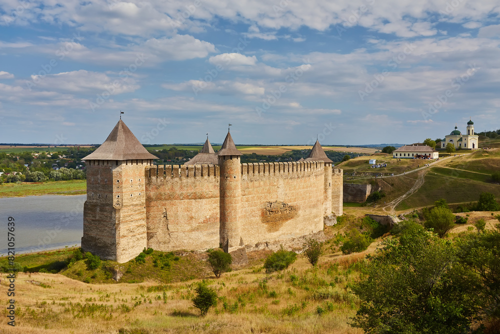 Khotyn fortress built in the 14th century. View of top of the fortress wall and towers among the hills closeup on background of Dniester river and its left bank at early springtime Khotyn fortress built in the 14th century. View of top of the fortress wall and towers among the hills closeup on background of Dniester river and its left bank at early springtime