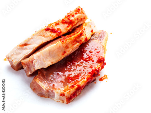 Pork chops in red Asian style marinade with chilly pepper. Fine pork meat for grill or summer barbecue. Popular dish with rich flavor. White background.