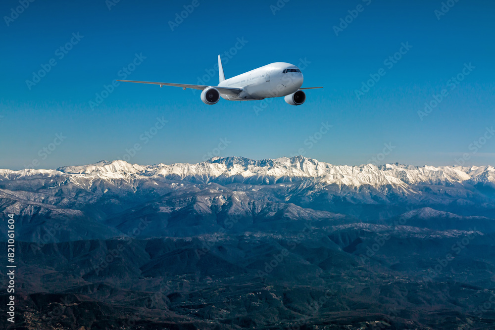 Fototapeta premium A white wide body aircraft fly over resort mountain town