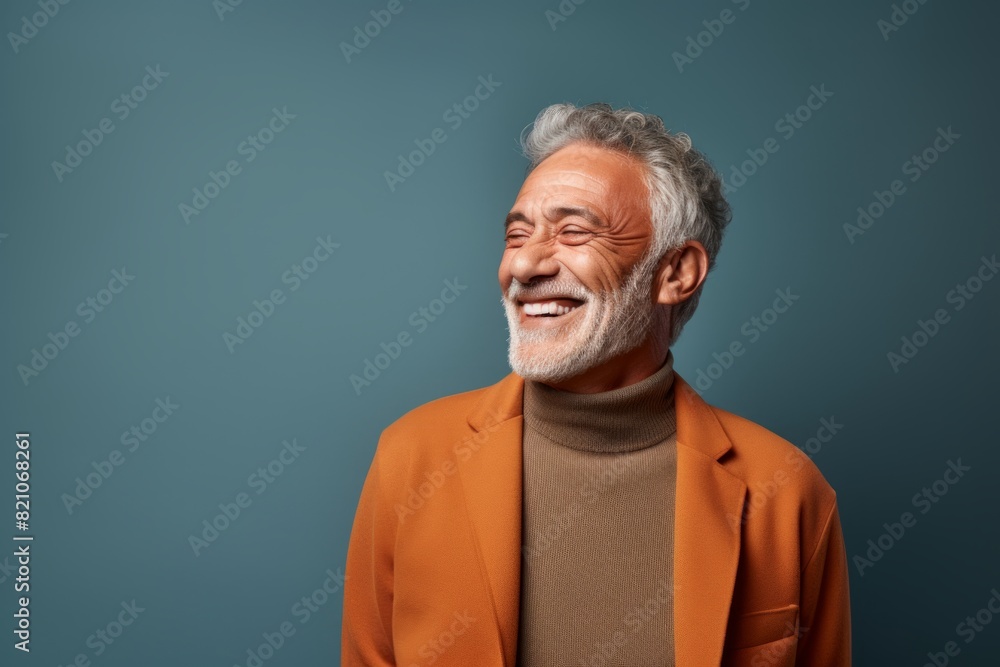 Portrait of a cheerful man in his 60s laughing in front of minimalist or empty room background Portrait of a cheerful man in his 60s laughing in front of minimalist or empty room background