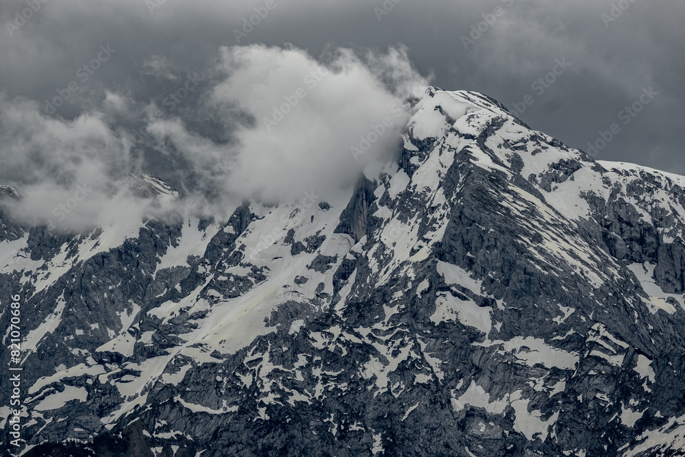 Alpine peaks rise through clouds, their jagged summits shrouded in mist. The scene captures the ethereal and majestic beauty of the towering mountains in soft, diffused light. Alpine peaks rise through clouds, their jagged summits shrouded in mist. The scene captures the ethereal and majestic beauty of the towering mountains in soft, diffused light.