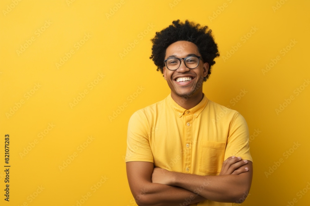 Portrait of a cheerful afro-american man in his 20s with arms crossed over minimalist or empty room background Portrait of a cheerful afro-american man in his 20s with arms crossed over minimalist or empty room background