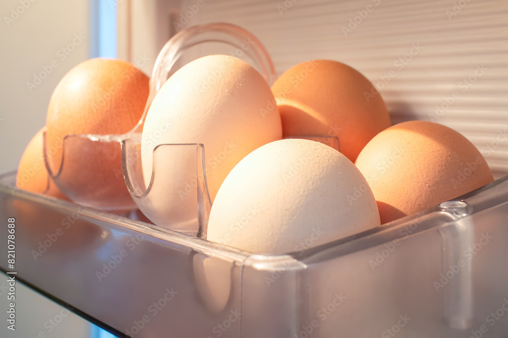 Organic eggs are stored in a transparent container inside a fridge, used as a key ingredient in various dishes, an oval staple food in different cuisines Organic eggs are stored in a transparent container inside a fridge, used as a key ingredient in various dishes, an oval staple food in different cuisines
