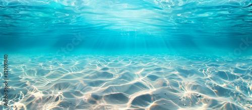 Blue tropical ocean with seabed sand below, serene underwater scene under the summer sun, casting shimmering ripples in the calm sea water