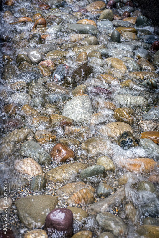 Smooth river stones in this moving stream of water.
