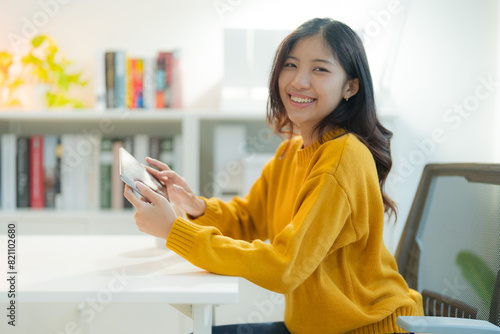 Young asian woman using smartphone in modern home office