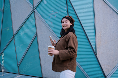 Stylish Woman with Coffee and Smartphone in Urban Setting