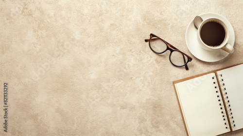 Still life with a notepad, glasses and a cup of coffee on a beige background. Creativity concept.