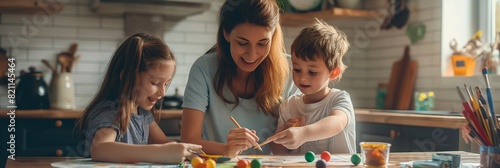 A mother and her two children enjoy a creative painting session together at home with colorful art supplies photo